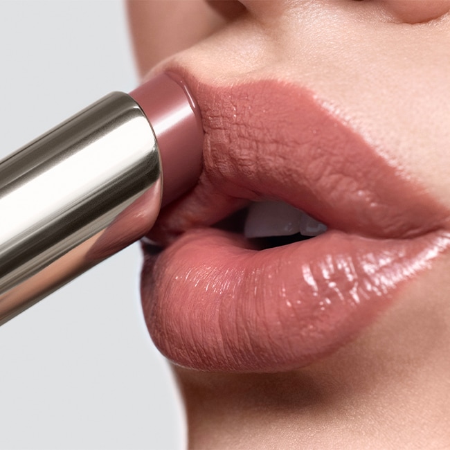 Close up of model applying Crushed-Oil Infused Gloss to lips